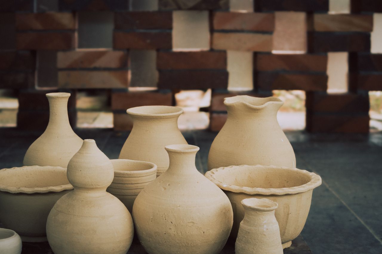 A variety of handmade clay pots and vases displayed on a rustic surface, highlighting craftsmanship.